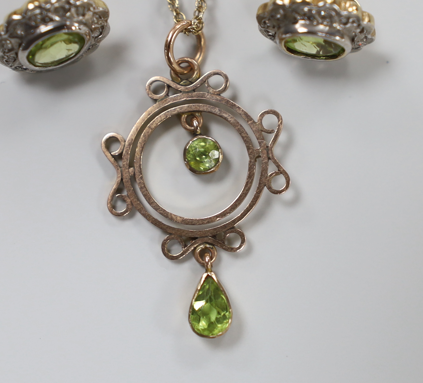 An early 20th century rose gold and peridot pendant necklace, on later chain, gross 3.5 grams and a pair of paste set ear studs